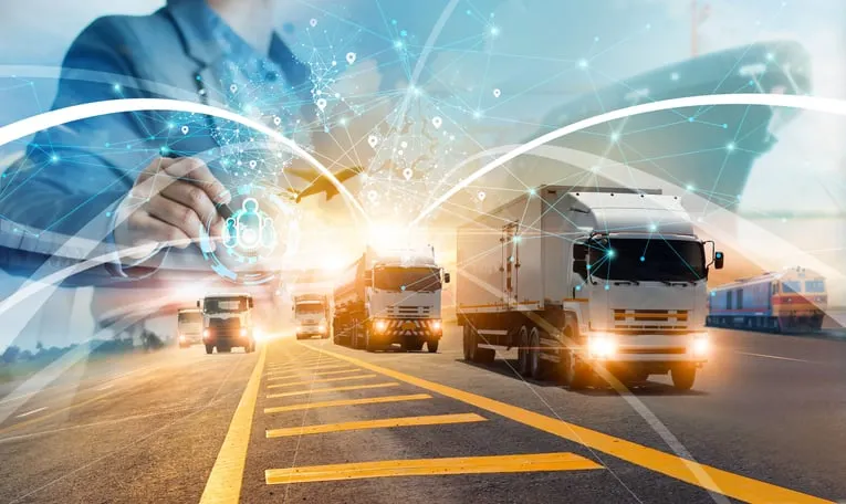 Digital network visualization overlaid on transportation trucks on highway, representing AI integration in logistics